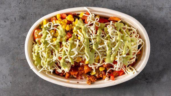 Savor the boldness of Mexican spices in this loaded chicken bowl, topped with melted cheese, corn, and a drizzle of green sauce.