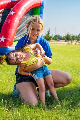 Coach Hannah posing with a kid having fun at the carnival