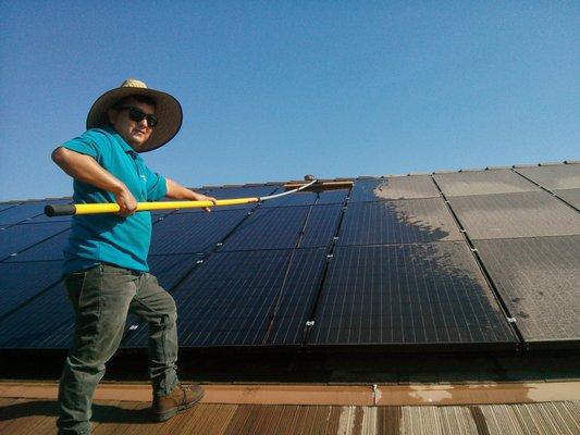 Jonathan cleaning solar panels from the bottom.