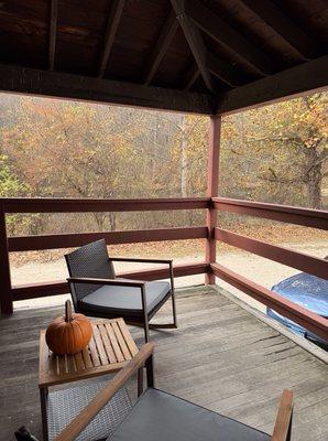 sitting area on porch overlooking woods and pond