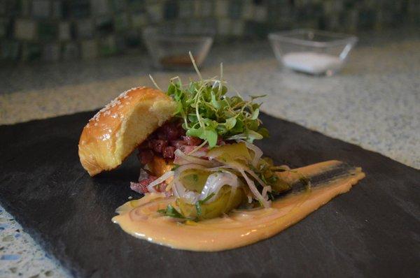 Steak Tartare, sesame brioche, mustard greens, cornichon shallot salad, secret sabayon