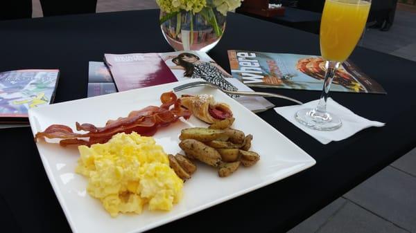 Catered breakfast. Eggs bacon delicious strawberry crossiant and seasoned potatoes.