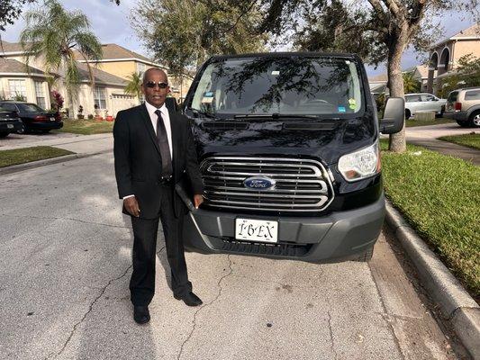 Ibex Town Car owner, Jamal Omar, standing behind his luxury van.