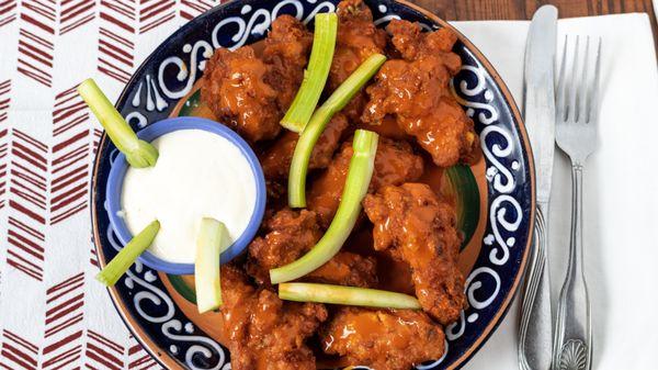 Buffalo wings, served with strips of celery and blue cheese