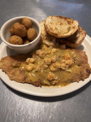 Fish, crawfish étouffée, garlic bread, and hush puppies