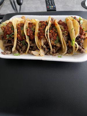 Steak tacos with cilantro & onions, spicy red sauce.