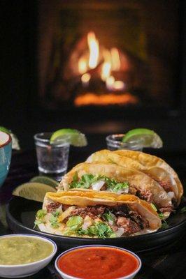 Tacos and tequila shots near the fireplace in the lounge