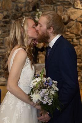 Bride and Groom in wedding ceremony first kiss.