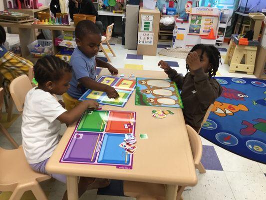 Children engaged in "hands-on learning stations"  and "manipulative centers."  Learning through PLAY.