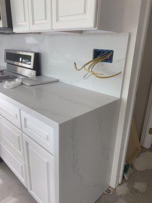 Countertop with waterfall edge and backsplash all quartz. Veins match at edge!