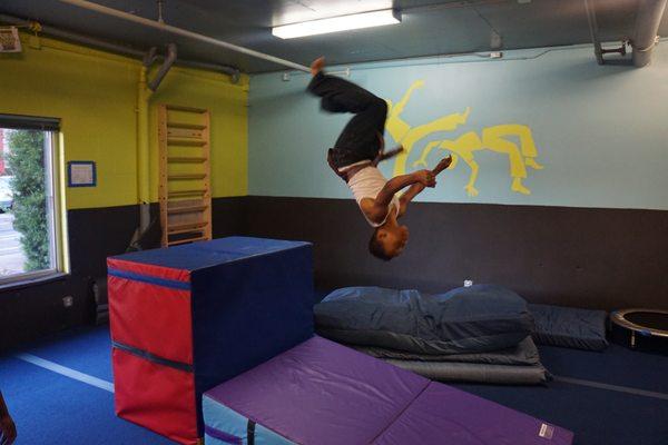 One of our students practices his back flips on the mats.