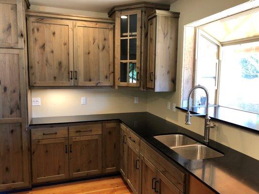 Black Soapstone Counters that are perfectly matched with a knotty wood cabinet.