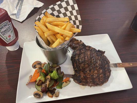 Fire grilled Ribeye steak with grilled veggies, fries and a Mexican glass coke.