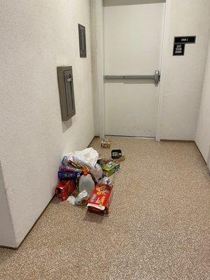 trash left in the middle of the stairway right in front of the emergency exit. Trash will sit there for days.