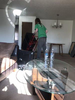 A mover taking furniture out via dolly