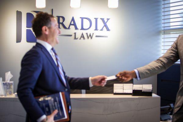 Business attorney Andy Kvesic greets a client in the reception area.