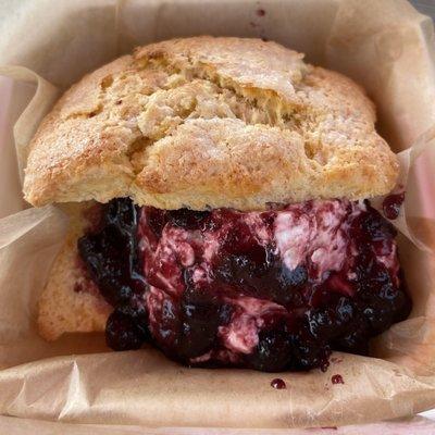 Scone with whipped cream and blueberry jam