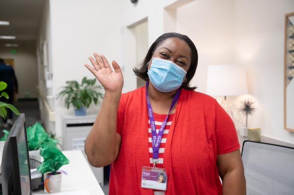 PACE East Oakland staff member waves hello to guests.