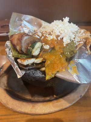 Molcajete includes beef and chicken fajitas,sausage,nopales,cheese and a jalapeño bacon wrap