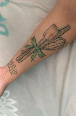 Large pastry tattoo:  spatula, french rolling pin and whisk all wrapped  together with perfect turquoise bow