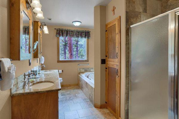 Large bathroom with double sinks, large jetted tub for two, and oversized shower with double sided body spray shower heads