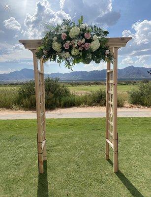 Wooden arch decoration with cascading flowers at Painted Dunes Golf Course