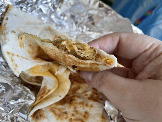 Inside of chicken quesadilla (cheese, shredded chicken, sauce)