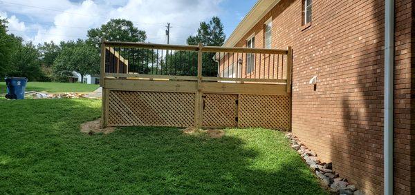 Back view with latice and a door to underneath the deck