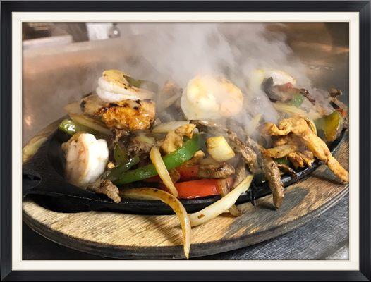 Delicious Texas Fajitas (steak, shrimp & chicken) loaded with veggies.