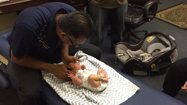 a newborn baby girl getting adjusted to help clear up any subluxations caused during labor.