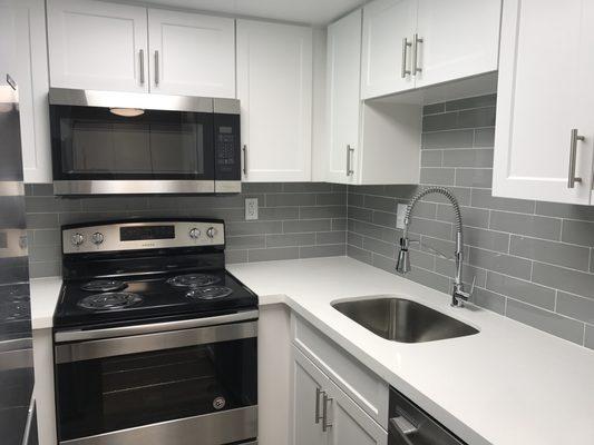 Newly renovated apartments with quartz counters and glass tile backsplash.