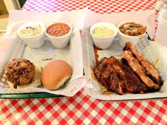 Pulled pork sandwich and ribs. Sides are: baked beans, coleslaw, potatoe salad, and candied yams