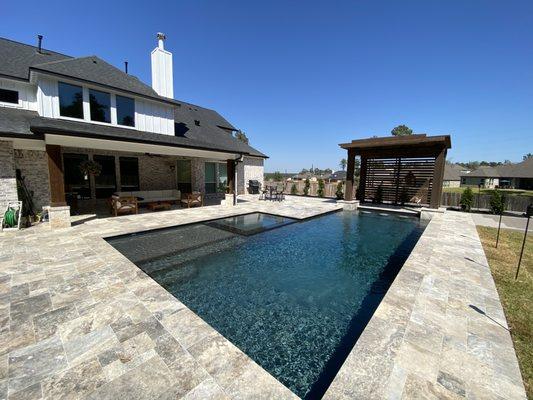 Our pool construction included an Infinity spa, and a custom pergola with a rain curtain flowing into the pool.