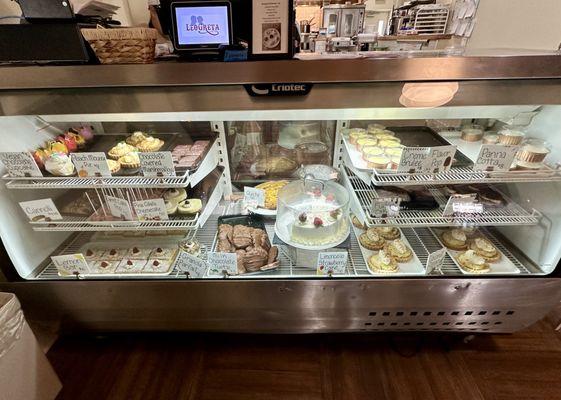 Display case of cupcakes, pies, creme brûlée, panna cotta, etcetera