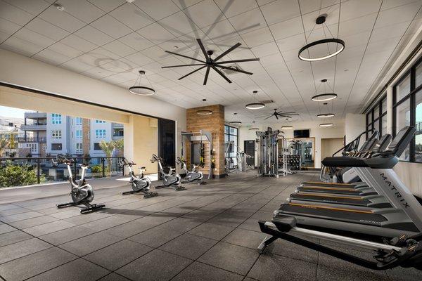 Fitness center with outdoor spin deck overlooking pool