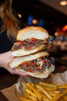 Our Steak & Cheese Sandwich made with shaved steak, swiss cheese, sautéed peppers & onions, garlic mayo on a toasted roll