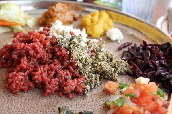 Kitfo is the steak tartare of Ethiopia, the gomen kitfo is the greens with cheese to the right, and delicious beets.