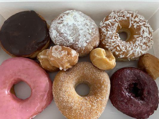 Starting from top left clockwise: Boston creme, jelly, coconut, red velvet, cinnamon sugar, and strawberry glazed