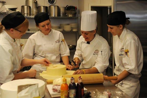 Escoffier Boulder students receiving hands on instruction from Chef Amy.