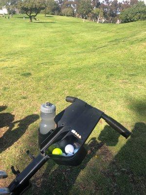 Golf balls in gold cart.