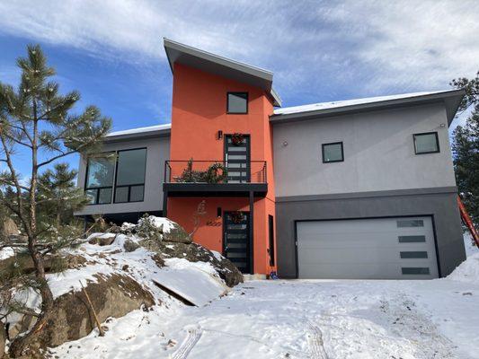 Front entry with elevator tower and garage.