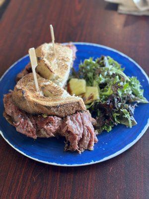 Pastrami on rustic bread with green salad