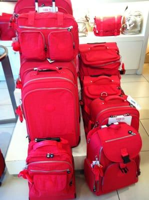 Neon red luggage. By: LEO