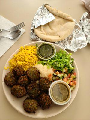 Plate with falafel, hummus, seasoned rice, romaine & tomato cucumber salad. Side of fresh pita as well.