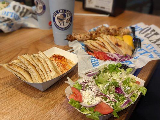 Chicken Souvlaki plate with rice on the right (salad comes with it). Side of pita and hummus on the left