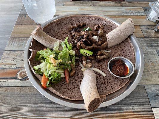 Zilzil Tibs served over injera with awaze sauce