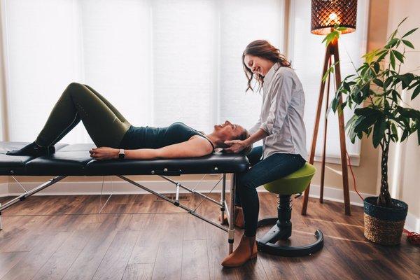 Dr. Molly helping a patient alleviate neck pain with a hands-on technique called manual cervical traction.