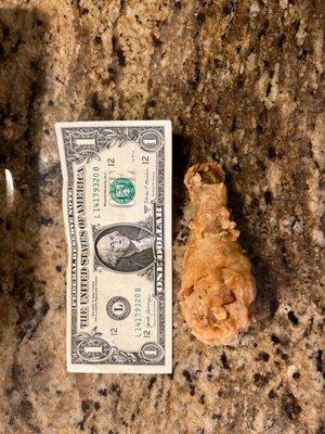 Chicken Express leg with a dollar bill for comparison. I have seen bigger wings! What a rip off!