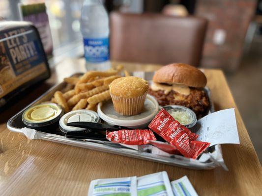 Chicken sandwich with greens, fries, and muffin