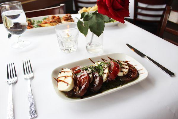 Our summer salad has fresh heirloom tomatoes, basil oil, a balsamic reduction and delicious mozzarella cheese